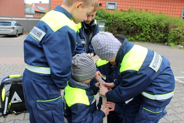 Spiel 4: Eine Murmel soll durch die 15 m D-Schlauch durch, Foto: Freiwillige Feuerwehr Heiligendorf