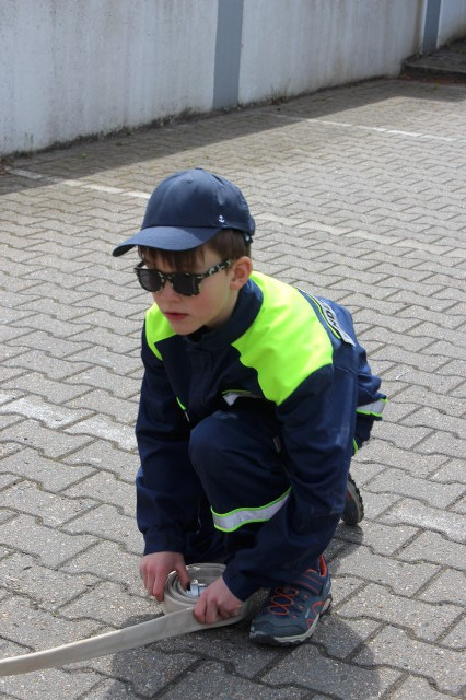 Spiel 4: Eine Murmel soll durch die 15 m D-Schlauch durch, Foto: Freiwillige Feuerwehr Heiligendorf